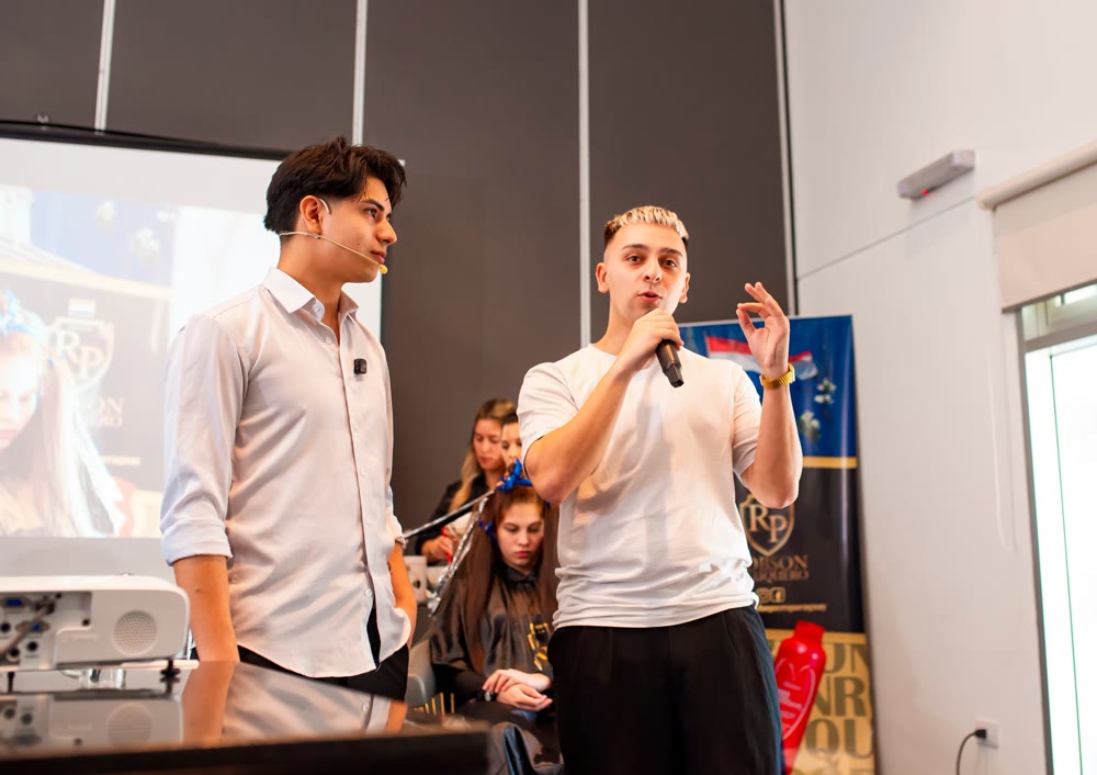Catriel hablando con micrófono en el evento de Robson Peluquero en Paraguay